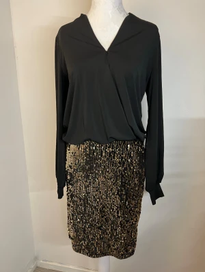 Klänning - Sjukt fin klänning från Happy Holly med långärmad omlottopp och en kjol täckt av glittriga guldpaljetter. Helt ny och aldrig använd. Storlek 36/38. 🖤