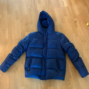 Mörkblå pufferjacka från Calvin Klein - Tja! Säljer en fin pufferjacka i mörkblå från Calvin Klein då den är lite för stor för mig. Jag är 170 och skulle säga att den passar dig som är 175-185. Nypris på jackan är 2800kr. Inga defekter. Tvivla inte på att höra av er vid minsta fundering! Jackan passar vem som helst och kan piffa till varje människas dagliga outfit när det är kallt ute. Ha det så fint!