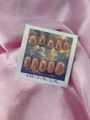 Fairycore (XS);ExtraShortOval  - Handgjorda press on-naglar i en mjuk nude-rosa färg med rundad form och roséguldglittriga detaljer. Snyggt glansiga och perfekta för att ge dina naglar en lyxig touch. Kommer i storlek XS: 14 mm, 11 mm, 11,5 mm, 10 mm, 8 mm  och är lätta att applicera hemma.