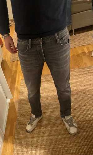 Grå jeans från Jack & Jones - Säljer ett par grå jeans från Jack & Jones med stilrena diskreta slitningar. Jeansen har rak passform och normal midja, tillverkade i mjukt denimtyg. Jeansen är helt nya och använda endast en gång! Tveka inte om att höra av dig om frågor eller prisförslag!