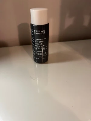 Paula's Choice 2% BHA Liquid Exfoliant - Paula's Choice Skin Perfecting 2% BHA Liquid Exfoliant i svart plastflaska med vit skruvkork. Innehåller salicylsyra och passar alla hudtyper. Flaskan rymmer 30 ml och är perfekt för att rengöra porer och jämna ut hudtonen. Jag är öppen för prisförslag! 