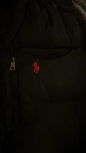 Svart dunjacka från Polo Ralph Lauren - Jag säljer min polo Ralph lauren jacka, eftersom att den inte passar mig och det är lite krångel med vänster armen på jackan. Jag fick jackan som present så jag har inte kvitto tyvärr men min mormor som köpte den sa att hon köpte den från boozt för 6000kr anledning till varför jag säljer den för 2799 är för att den är lite krånglig på vänstra armen men det är inget synligt det är inne i jackan det finns QR kod och den är jätte skön och varm.