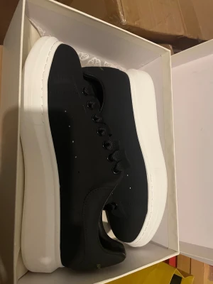 Alexander McQueen svarta sneakers - Stilrena svarta sneakers från Alexander McQueen med chunky vit platt sula och klassisk snörning. Storlek 43/44 skulle passa smala långa fötter. Tillbehör tillkommer som finns i bilderna! Fraktar samma dag eller därpå‼️🤙