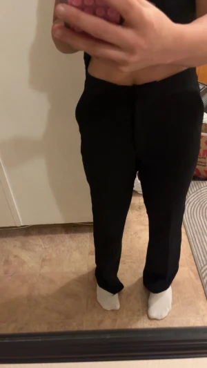 Svarta kostymbyxor med högmidja - Säljer ett par svarta kostymbyxor med rak passform och klassisk look. Byxorna har hög midja och är tillverkade i ett slätt material som ger en stilren siluett. Perfekta för dig som gillar enkel och clean stil. Byxorna är använda 2 gånger som nya! Priset går att diskutera 