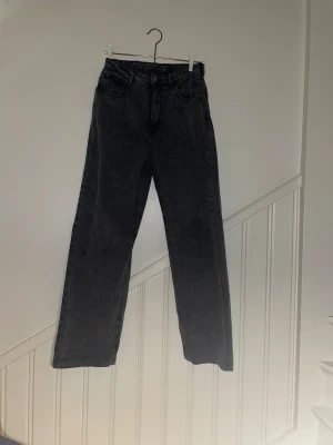 Svarta raka jeans från Boohoo - Säljer ett par svarta jeans från Boohoo i storlek 38. Jeansen har raka ben, klassisk femficksmodell och hög midja. Materialet är denim och färgen är tvättad svart för en cool, avslappnad look. KOLLA BILD TRE FÖR STRL OCH TYDLIGARE FÄRG.