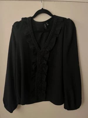 Svart blus - En superfin svart blus med volanger.