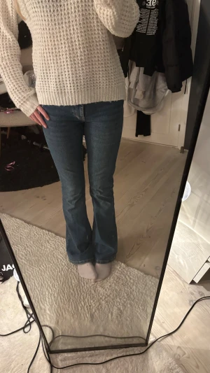 Blå bootcut jeans - Snygga blå jeans från Gina med låg midja och klassisk bootcut-passform. Jeansen har fem fickor, knapp och dragkedja framtill samt är tillverkade i slitstarkt denim. Perfekta för dig som gillar retrovibbar och vill ha en cool siluett.