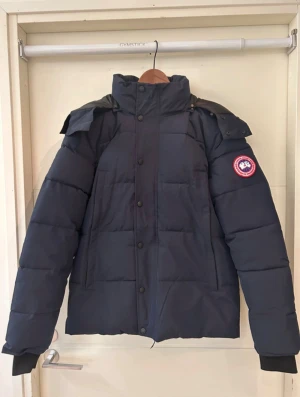Svart Canada Goose Wyndham - 1600 inte mindre. Riktigt skön och bra jacka. Är lite stor i storleken men de står S på den fast den är som M