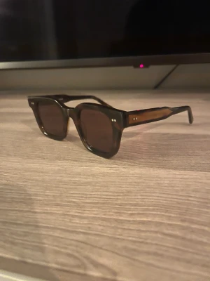 CHIMI 04 - Snygga solglasögon från CHIMI i modellen 04, designade i Stockholm. De har en fyrkantig form och är tillverkade i brunt acetat med mörka linser. Perfekta för dig som vill ha en stilren och trendig look. Kommer i originalfodral. Skick9/10