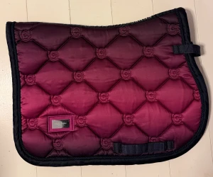 Schabrak i strl ponny från Equestrian Stockholm  - Snyggt schabrak från Equestrian Stockholm i storlek ponny. Fint skick, dock några repor på loggan (metallen) men inget som stör, syns knappt. 