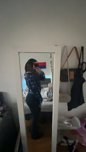 Mörkblå hoodie med hjärtan - Säljer en mörkblå hoodie med ljusblå hjärtmönster och huva. Tröjan har långa ärmar och ribbade muddar vid ärmslut och nederkant. Perfekt för dig som gillar gulliga detaljer och vill ha en mysig stil.