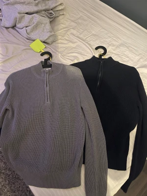 Grå stickad half zip tröja Grunt M båda två är strl M - Säljer en grå stickad tröja från Grunt i storlek M. Tröjan har en ribbad struktur och en half zip-dragkedja vid halsen. Perfekt för dig som gillar enkel och stilren design med långärmad passform.
