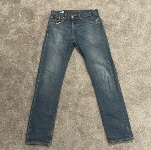 Levi’s 502 - Klassiska blå Levi's 502. Jeansen är använda sparsamt och därför i väldigt bra skick. Små defekter ner vid byx kanterna men annars felfria.     Hör av dig vid fler frågor!