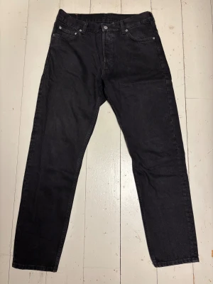 Svarta Weekday Barrel jeans 31/32 - Svarta jeans från Weekday i modellen Barrel med raka ben. Snygg, enkel look som passar till det mesta. Stängs med knappar framtill. Helt vanliga svarta jeans från weekday, inget märkvärdigt. Riktigt snygga dock synd att de är för små för mig. Har knappt använt de så de är som nya. 
