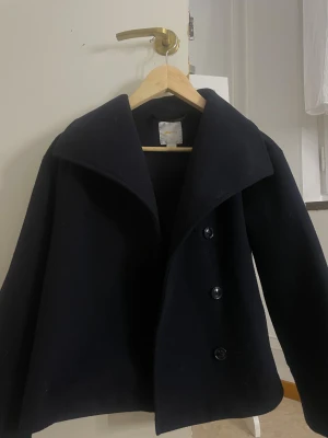 Marinblå kappa  - Kappa från Gina i stl 152, fick fabrikatsfel på den så den är större än va stl visar. Ja skulle säga att de är en xs 