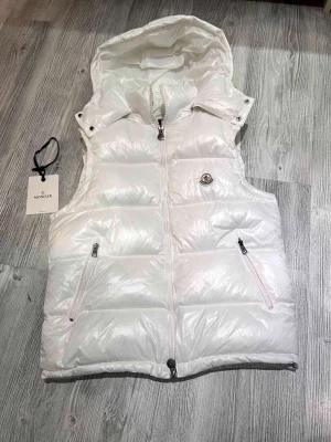 Moncler väst  - Hej! Jag säljer nu min moncler väst som är i nyskick den är andvänt väldigt sparsamt och inte alls länge, den är absolut äkta och köpt ifrån Nk kvittot finns som bevis till det och nfc Scan funkar som den ska. original tillbehören ingår med jackan som taggarna og plastpåsen och dustbagen, priset är hugget i Sten hör av dig vid minsta lilla fråga!😄