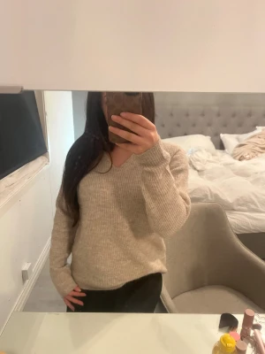 Beige ribbad stickad tröja v-ringad - Mysig beige stickad tröja med v-ringad hals och ribbad struktur. Använd fåtal gånger och inga defekter!