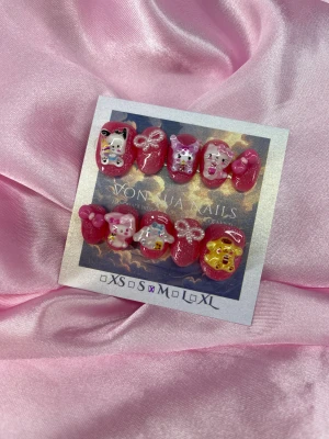 BubbleFriends (M);ExtraShortOval  - Supergulliga handgjorda press-on naglar i rosa med glitter och 3D dekorationer av populära Sanrio-karaktärer som Hello Kitty, Cinnamoroll och Pompompurin. Naglarna har en extra kort oval form och dekorerade med pärlor, rosetter och söta detaljer. Perfekt för dig som älskar kawaii och unika naglar.M: 16 mm, 12 mm, 12,5 mm, 11,5 mm, 10 mm 
