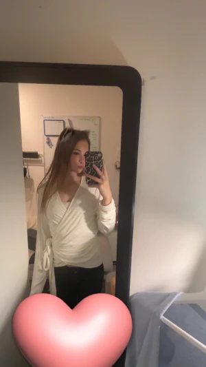 Vit omlottopp med knyt från 157 - Säljer en vit omlottopp från 157 med långa ärmar och snygg knytning i midjan. Toppen har v-ringad design och är gjord i mjuk bomull som känns skön mot huden. Perfekt att styla med jeans eller kjol för en fräsch look. också väldigt ny har använts 1 gång innan ❤️