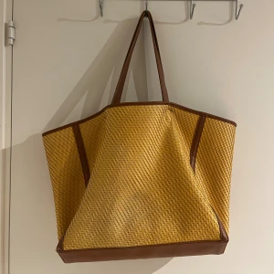 Gul Tote från Stylein - Height: 33 cm, Width: 40 cm, Handle: 58 cm. Använt skick därav lite slitna hörn samt en lite missfärgningar på båda sidorna men överlag ett bra skick.