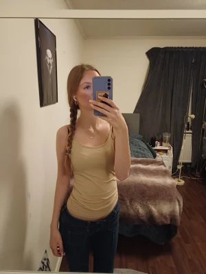 Beige linnetopp med smala axelband - Snygg beige linnetopp med smala axelband och rundad halsringning. Modellen är tight och sitter nära kroppen, perfekt för dig som gillar en enkel toppen, skön att bära under varma dagar. Xs men om du har storlek kan du också ha den 