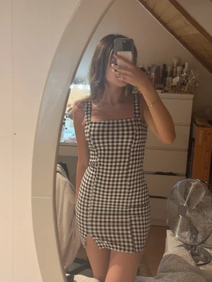 Svartvit rutig kort klänning - Superfin svartvit rutig klänning med breda axelband och fyrkantig urringning. Har knappt använt den, som ny💕