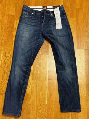Tramarossa Jeans - Säljer ett par exklusiva ”Leonardo” jeans från Tramarossa, storlek 30, total längd 95 cm. Blå med djup och elegant färg samt genomarbetade detaljer. Handgjorda i Italien av premiummaterial, med samtliga skräddare som deltagit i tillverkningen personligen signerade, ett tydligt kvalitets- och hantverksmärke.