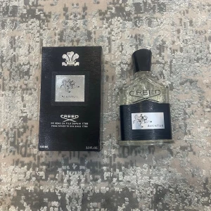 Creed Aventus Eau de Parfum 100ml - Creed Aventus Eau de Parfum är en exklusiv parfym i en elegant genomskinlig glasflaska med svart etikett och silverdetaljer. Flaskan har en svart kork och levereras i en lyxig svart kartong med silverlogga. Doften är ikonisk och passar dig som vill sticka ut.