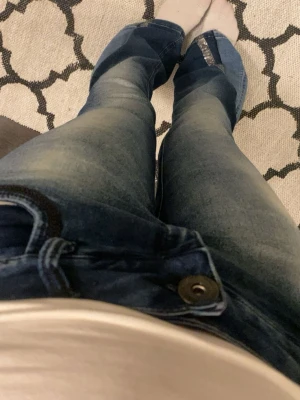 Blå bootcut jeans - Säljer ett par blå bootcut jeans med låg midja. Väldigt cool design. Säljer för att dom är lite stora för mig. Använda några få gånger. Dom är köpta secondhand 