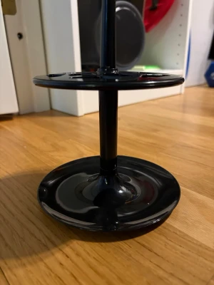 Svart sminkborsthållare i plast - Praktisk svart sminkborsthållare i plast med två runda plattor och flera hål för att organisera borstar. Perfekt för att hålla ordning på dina sminkverktyg på sminkbordet. Modern och stilren design som passar de flesta rum.