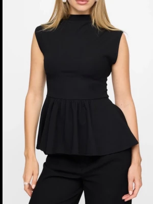 Svart peplum topp med hög hals - Snygg svart peplum topp med hög hals och ärmlös design. Toppen har en markerad midja och volang nedtill.