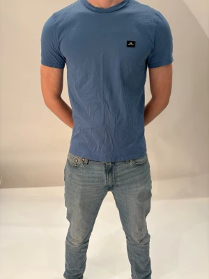 J Lindberg t-shirt -  Säljer en ljusblå J Lindberg, t-shirt i bra skick, storlek M