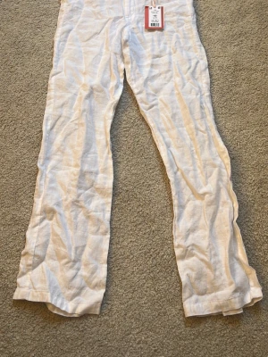 Vita linnebyxor från Gina Tricot LIMITED EDITION!! - Snygga vita linnebyxor från Gina Tricot i samarbete med Izandelle. Byxorna har raka ben, knapp och dragkedja framtill samt är tillverkade i ett luftigt linnematerial. 