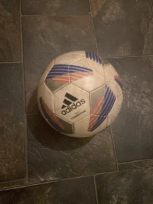 Adidas Tiro Competition fotboll - Säljer en Adidas Tiro Competition fotboll i vitt med blå, röda och silvriga detaljer. Klassisk sexkantig paneldesign och tydlig Adidas-logga. Perfekt för matcher eller träning på planen.