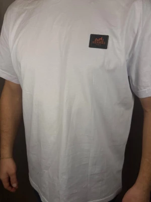 Vit t-shirt  - . T-shirten har rund hals och korta ärmar, perfekt för en clean och stilren look. Tillverkad i mjuk bomull för maximal komfort.