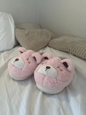 Rosa tofflor med nallebjörnsmotiv - Säljer  dessa super söta och sköna tofflor. storlek 40-41 men passar mig som bär 38. noppriga och ändrat färg innuti, därav priset. 