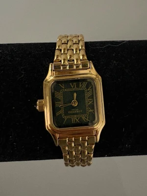 Liten guldig dam klocka - Säljer detta superfina armbandsur, superfin guldig färg med grönt i själva uret, det är aldrig använt och är ej avlänkad. Det tillkommer en box, kort, manual, och putsduk med klockan (se bild 2) Nypris: 1699kr🙌💕