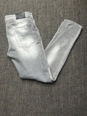 Grå skinny jeans från Croni - Sjukt feta grå skinny jeans från Croni med klassisk femficksdesign och diskreta slitningar på benen. Jeansen har en ljus tvätt och är tillverkade i mjukt bomullsmaterial med stretch för extra komfort. Riktigt unik färg. Jätte fint skick, tveka inte på att höra av er vid funderingar!