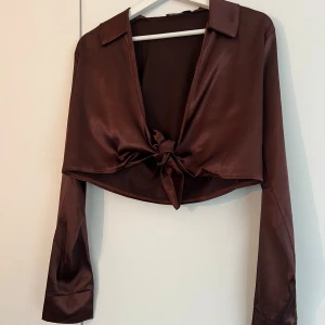 Brun satintopp - Brun satintopp med knyt från Nelly stl Xs.