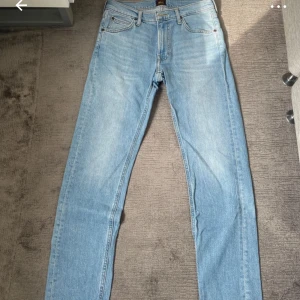 Ljusblå raka jeans från Lee - Snygga ljusblå jeans från Lee i klassisk rak modell. Jeansen har fem fickor, bälteshällor och är tillverkade i ekologisk bomull. Perfekta för dig som gillar en tidlös och avslappnad stil.