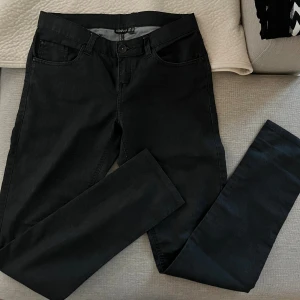 Svarta jeansbyxor från Esmara - Svarta jeansbyxor från Esmara i klassisk femficksmodell. Byxorna har normal passform och raka ben, med bälteshällor och knappstängning. Materialet är jeans och färgen är helsvart, vilket gör dem enkla att matcha med olika stilar.