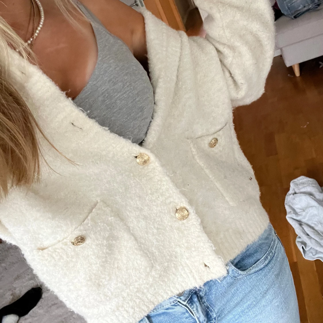 Vit fluffig kofta med guldknappar