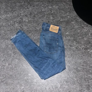 Blå Replay jeans - Snygga blå jeans från Replay med klassisk femficksdesign och läderpatch bak. Jeansen har en rak passform och är tillverkade i slitstarkt denim. Perfekta för dig som gillar en tidlös stil med coola detaljer och snygg tvätt.