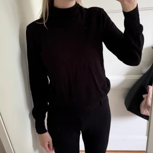 Svart polotröja  - Svart polotröja från H&M i storlek S. Tröjan har lång ärm och en klassisk polokrage. Materialet är mjukt och skönt, perfekt för lager-på-lager under hösten och vintern. Enkel och stilren design som funkar till många olika looks.