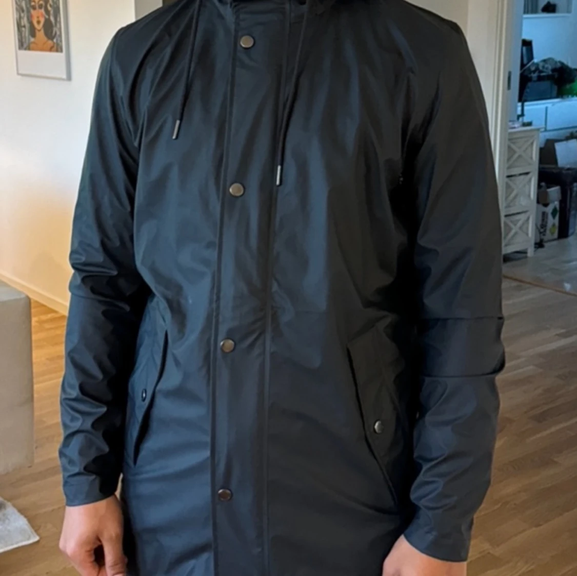 Svart regnjacka med huva