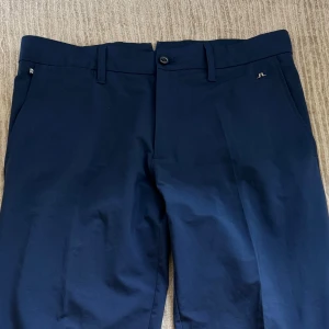 J.Lindeberg - Golfbyxor marinblå - Snygga mörkblå Golfbyxor från J.Lindeberg med klassisk rak passform. Använda ca 3 gånger nästintill nyskick. Sjukt snygga och tillverkade i ett mjukt bomullsmaterial med lite stretch. Nypris: 1300kr
