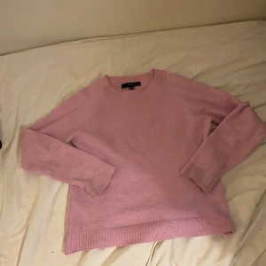 Ljusrosa stickad tröja från Filippa K - Supermysig ljusrosa stickad tröja från vera moda med rund halsringning och ribbade muddar. Perfekt för lager-på-lager och chill dagar. Snygg passform och enkel att matcha med jeans eller kjol.