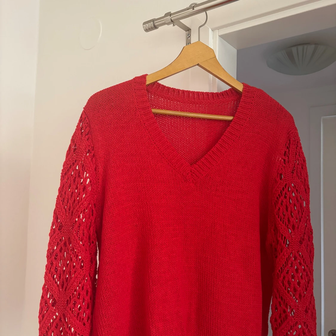 Röd stickad tröja med v-ringning