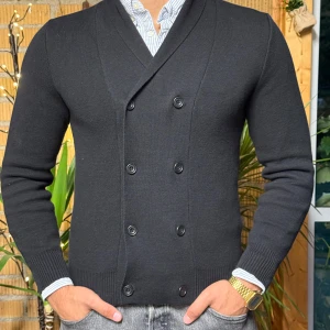 Svart dubbelknäppt kofta från Bläck - Stilren svart kofta från Bläck i storlek M. Koftan är dubbelknäppt med sex knappar framtill, har lång ärm och ribbade muddar. Snyggt skräddad passform och mjukt stickat material som passar perfekt till skjorta eller t-shirt.