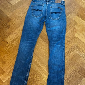 Blå skinny jeans från Nudie Jeans Lean dean - Snygga blå jeans från Nudie Jeans i modellen lean dean. Klassisk femficksdesign med kontrastsömmar och ikonisk broderad bakficka. Tillverkade i stretchig denim av 98% bomull och 2% elastan för en bekväm passform. Pris inte hugget i sten.